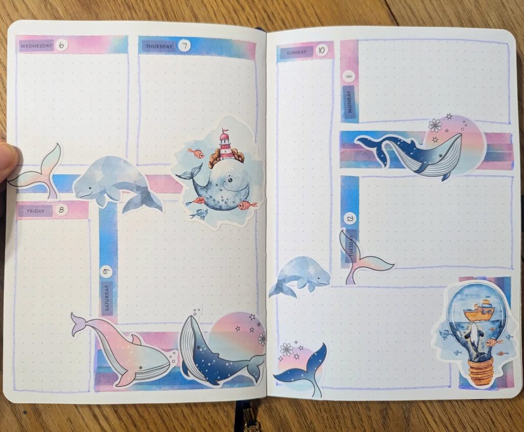 Weekly planner with ocean-themed stickers featuring whales and colorful designs across the pages.