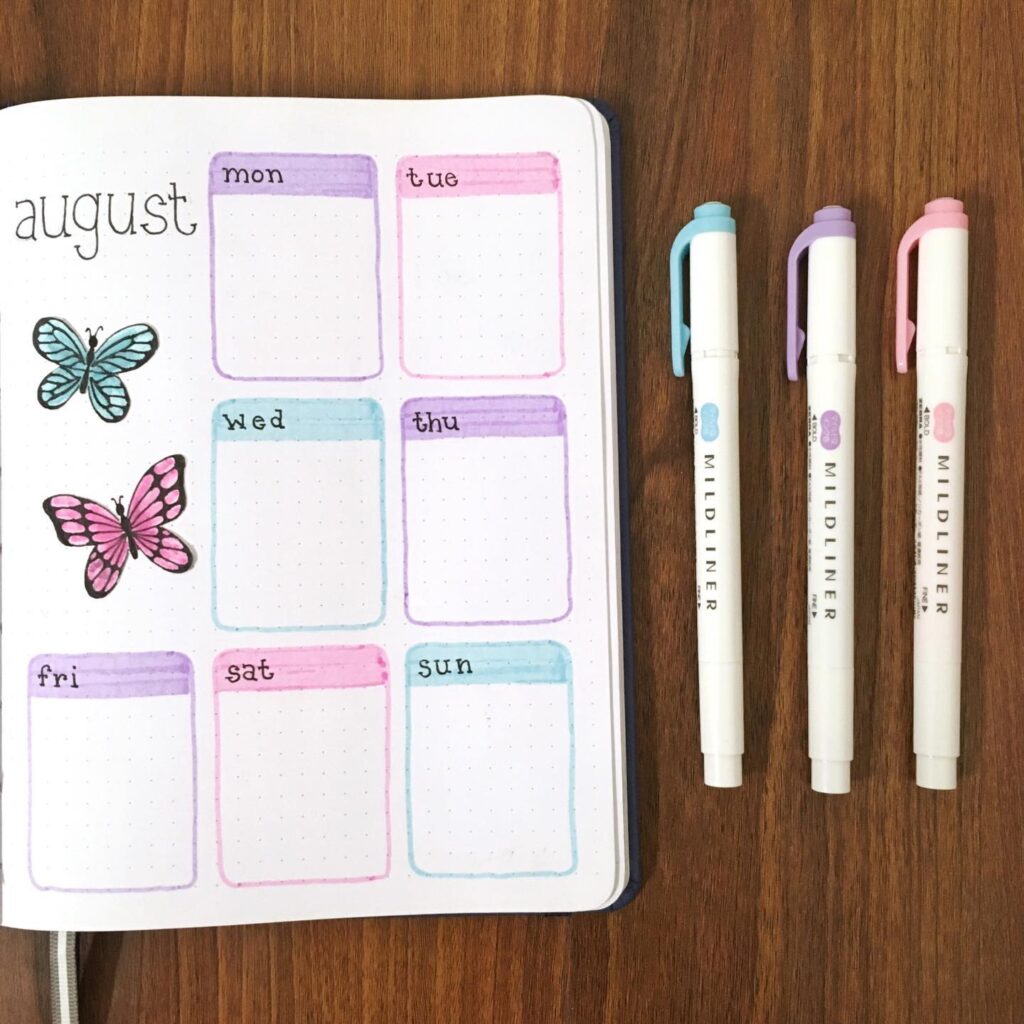 August bullet journal with butterflies. Colorful Mildliner pens on right for planning.