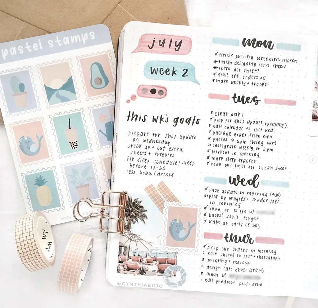 Bullet journal layout with weekly goals and pastel stamps. Includes decorative tape and a binder clip.