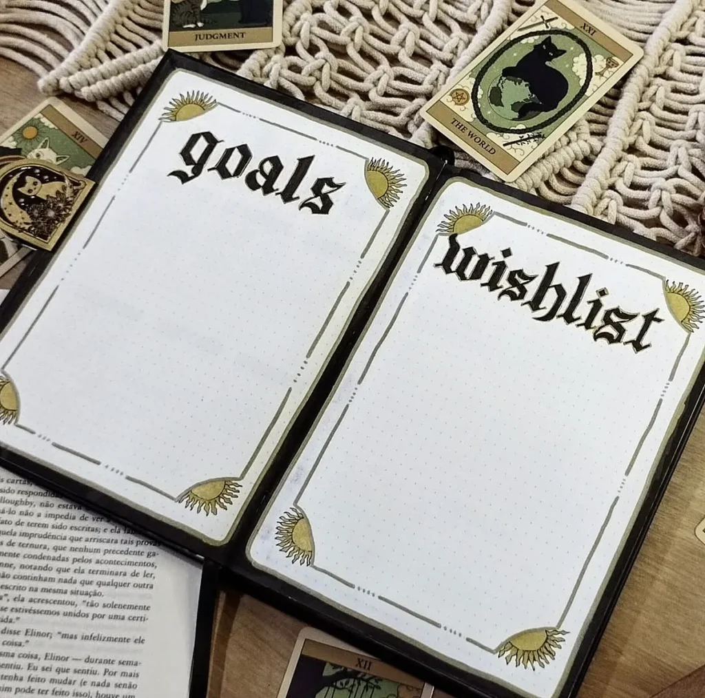 Open bullet journal with “goals” and “wishlist” pages, surrounded by tarot cards and a macrame pattern.