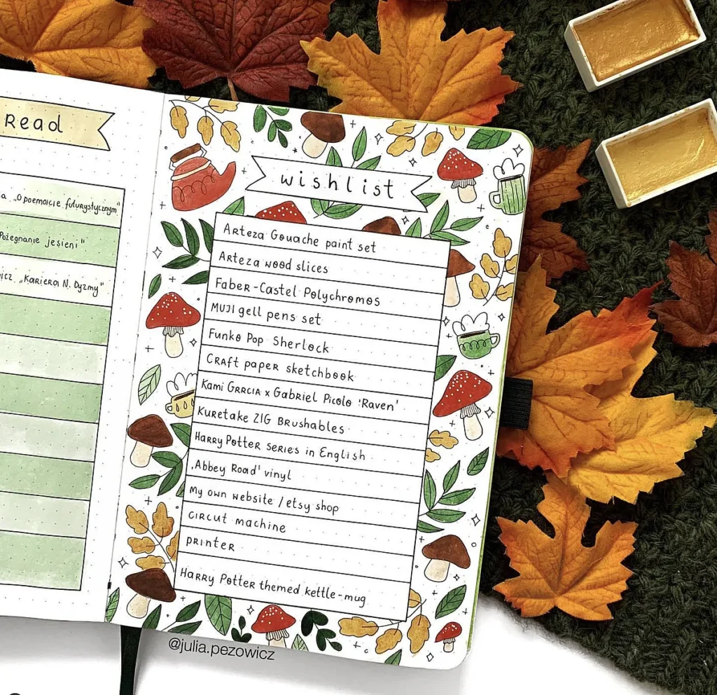 Autumn-themed wishlist journal page with stationery and book items, surrounded by colorful leaves and art supplies.