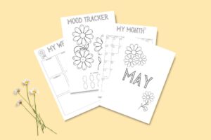 Printable May Bullet journal with mood tracker and calendar pages on yellow background, featuring flower designs.