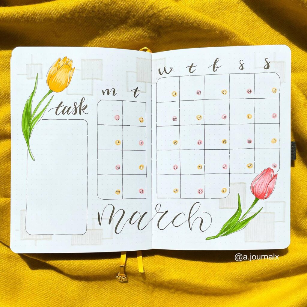 March bullet journal calendar with tulip drawings on a yellow fabric background.