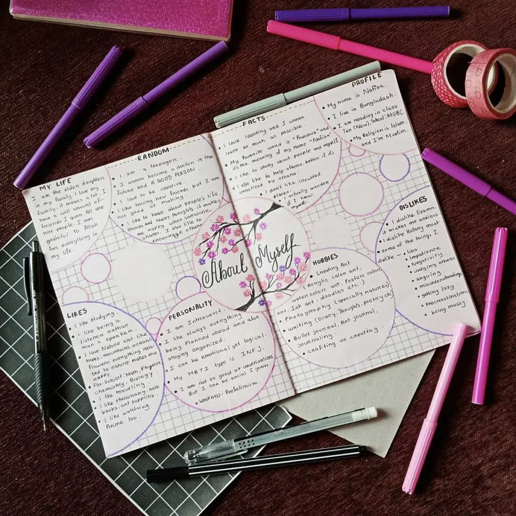 Open journal with About Myself section, surrounded by pens and washi tape on a maroon surface.