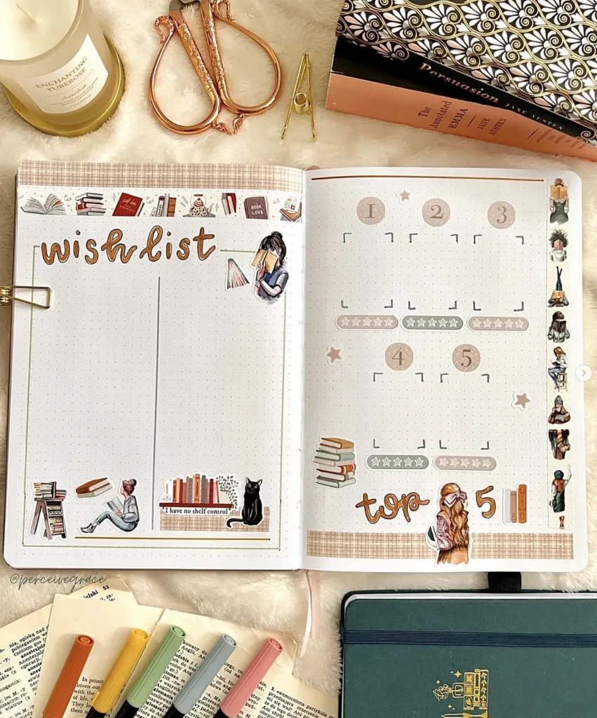 Open journal with wishlist and top 5 sections, surrounded by colorful pens, books, and cozy decor items.