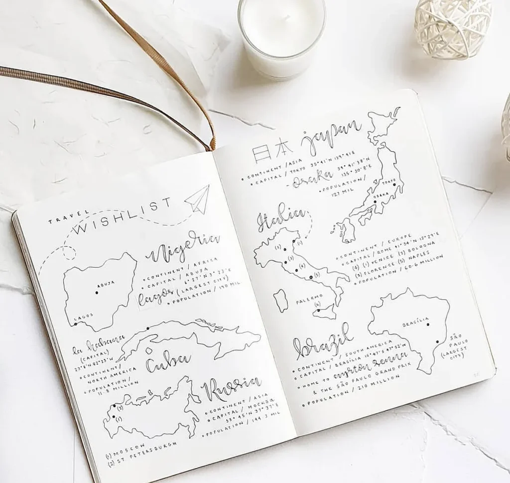 Open travel wishlist journal featuring maps of Nigeria, Japan, Russia, and more. Candle and decor elements visible.