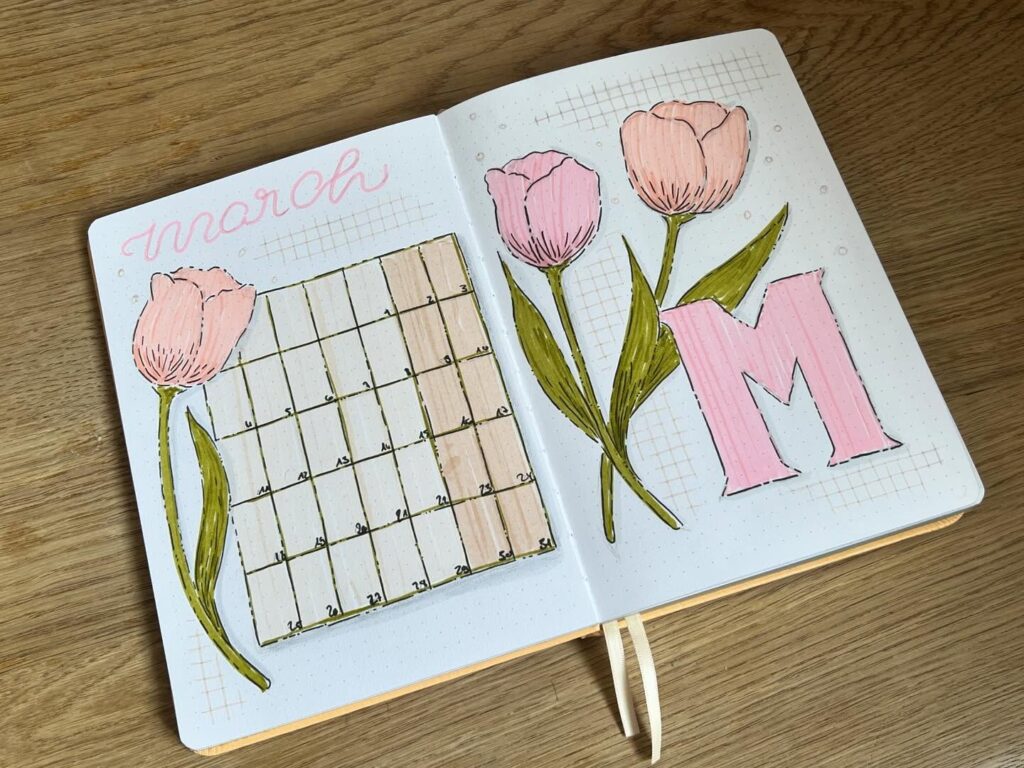 March bullet journal layout with hand-drawn tulips, calendar, and decorative M on dotted pages.
