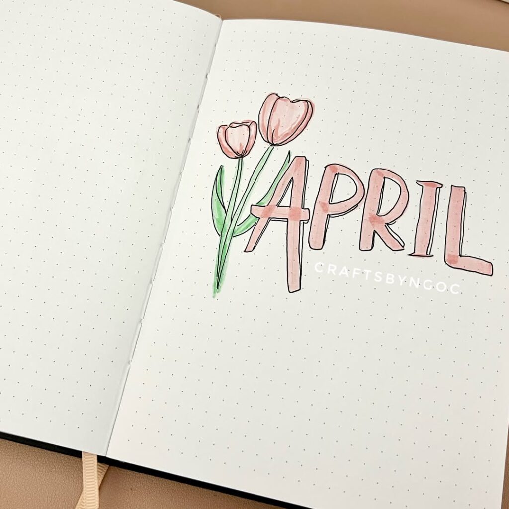 Bullet journal with April and tulip drawings, pink and green, on dotted pages.