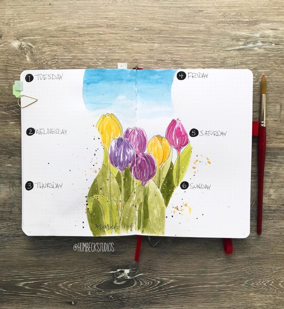 Bullet journal weekly spread with watercolor tulips for March 1-6. Brush and pen on rustic wood background.