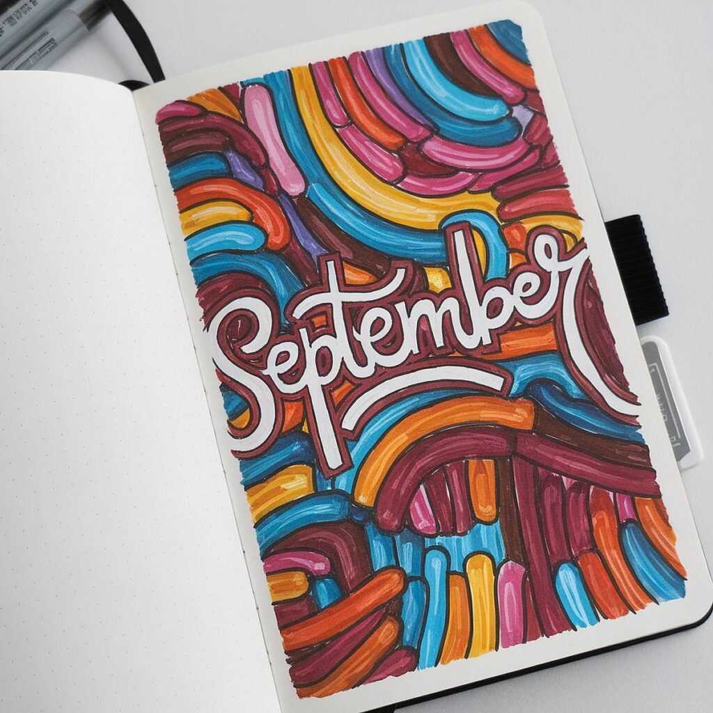 Colorful journal page with September in bold letters, surrounded by vibrant abstract designs.
