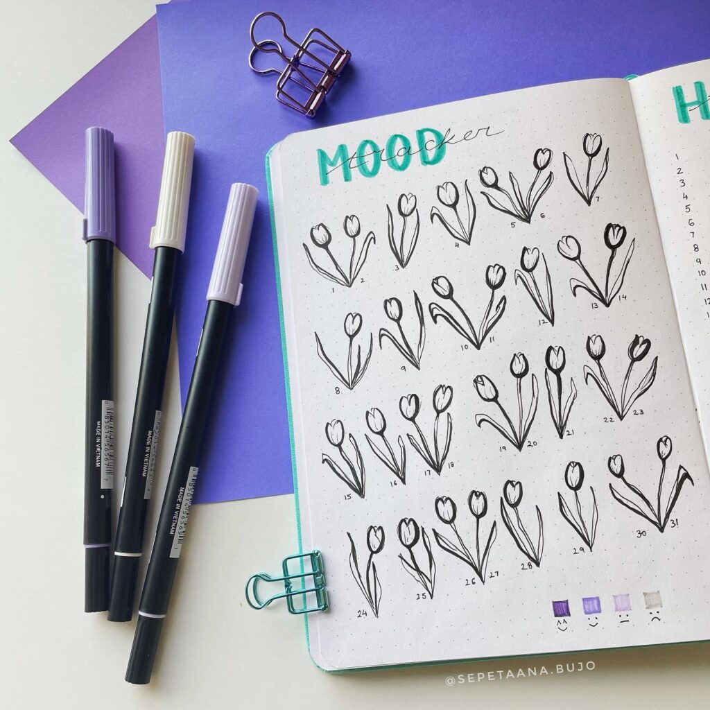 Bullet journal mood tracker with tulip drawings and pastel markers, on a vibrant purple background.