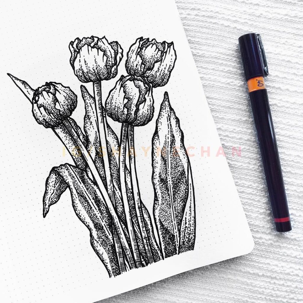 Black and white tulip sketch on dotted paper next to a black pen.