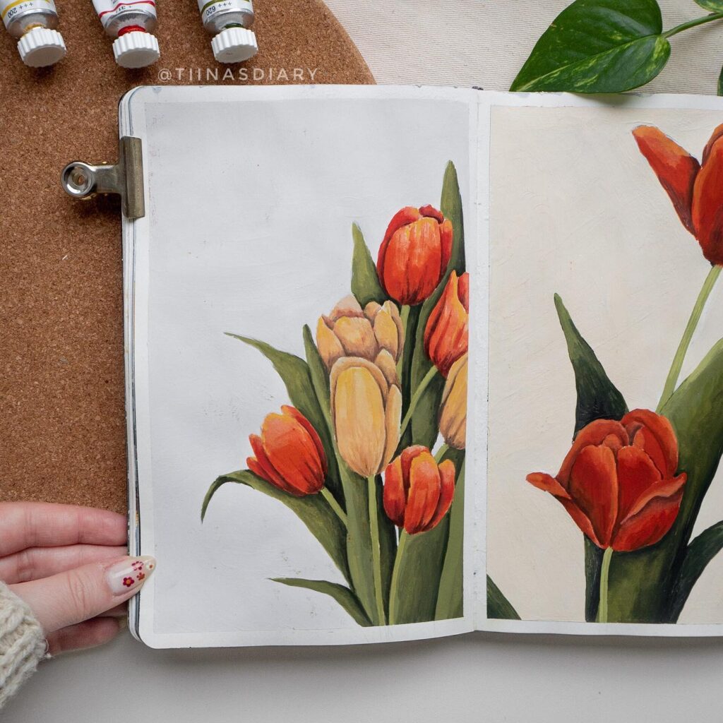 Sketchbook illustration of vibrant red and yellow tulips, surrounded by art supplies and a green leaf.