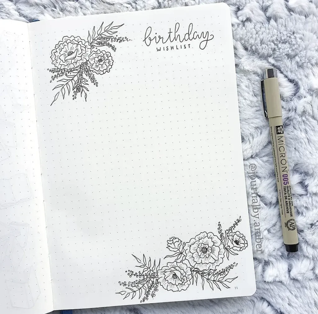 Birthday wishlist journal page with floral doodles, dotted pattern, and a Pigma Micron pen on a textured surface.