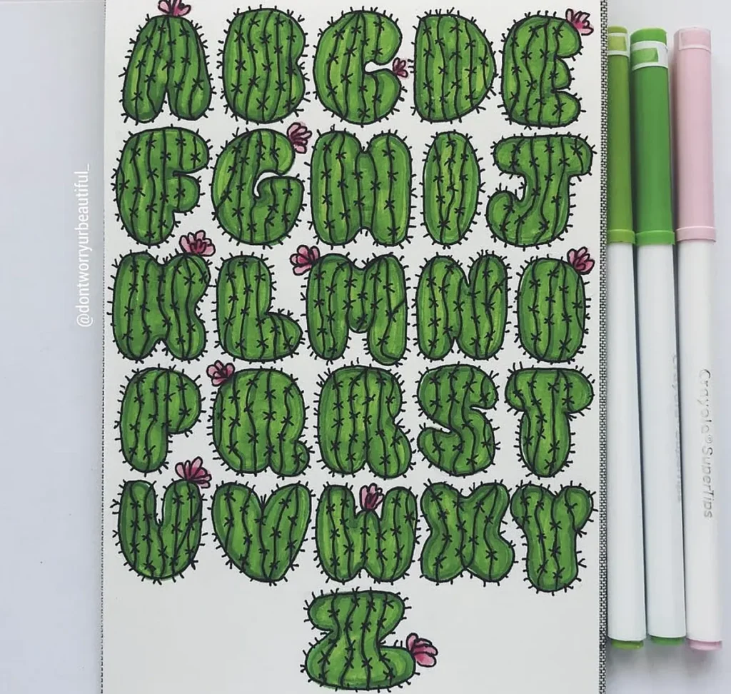 Alphabet letters illustrated as green cacti, adorned with pink flowers, next to colorful markers.