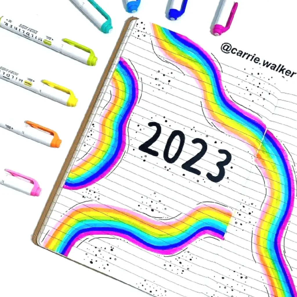 Colorful 2023 notebook design with rainbow patterns and markers, ideal for creative planning and inspiration.