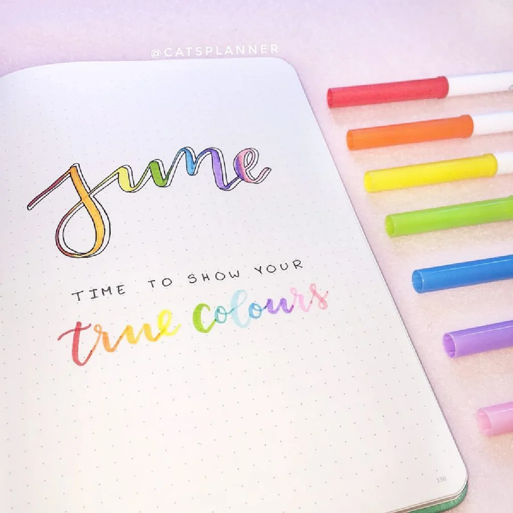 Colorful bullet journal page for June with pens, featuring the phrase Time to show your true colors.