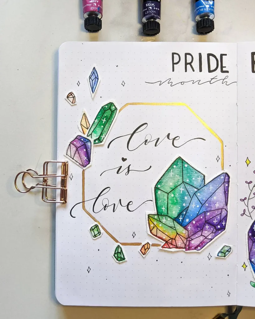 Notebook page with colorful crystal designs, the text love is love, and PRIDE month header.