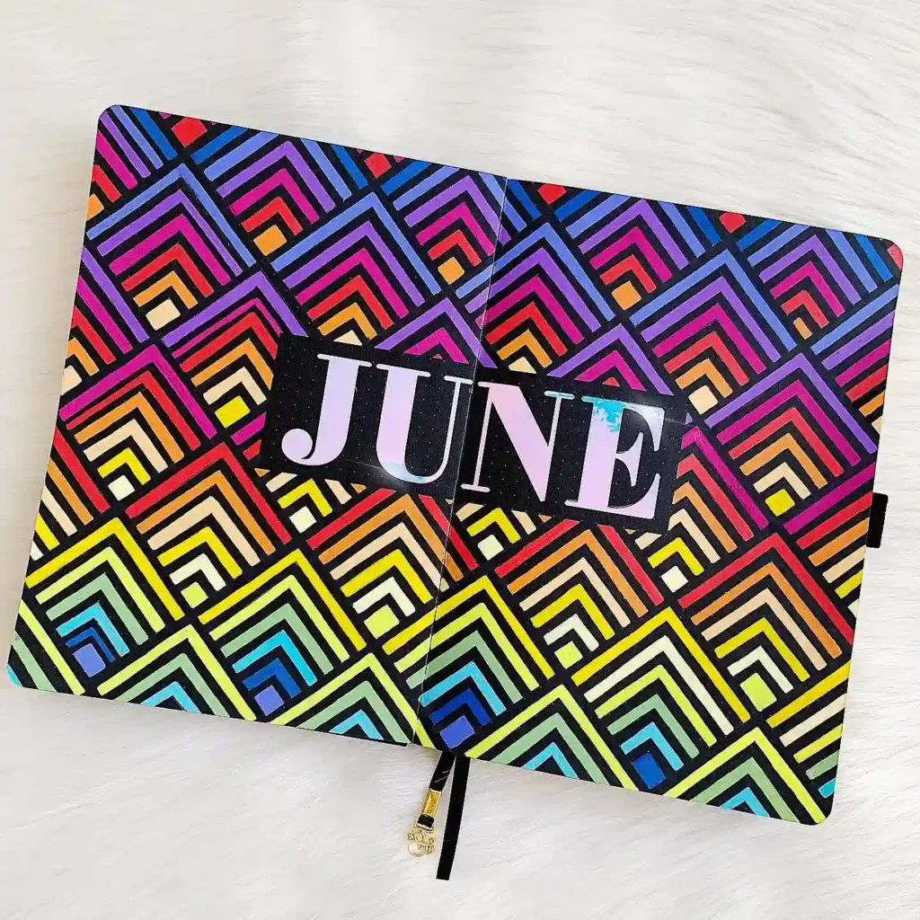 Colorful geometric June calendar design in journal, featuring vibrant retro patterns with rainbow hues.