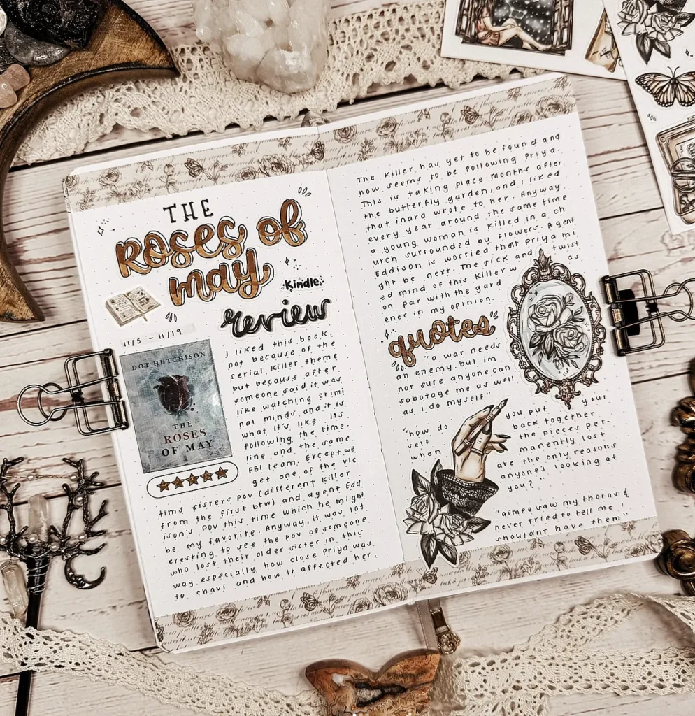 Decorative journal spread featuring 'The Roses of May' book review, quotes, and artistic embellishments on a wooden table.