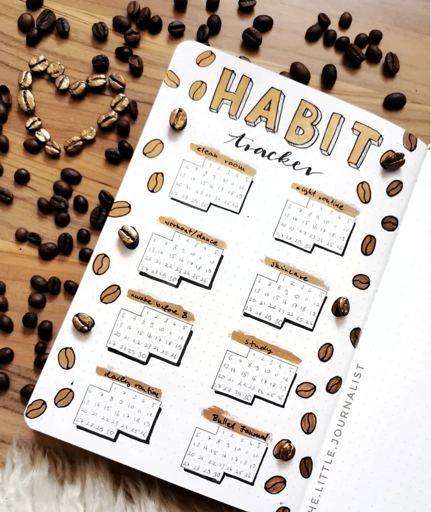 Bullet journal habit tracker with coffee bean design, featuring monthly goals on a wooden table.