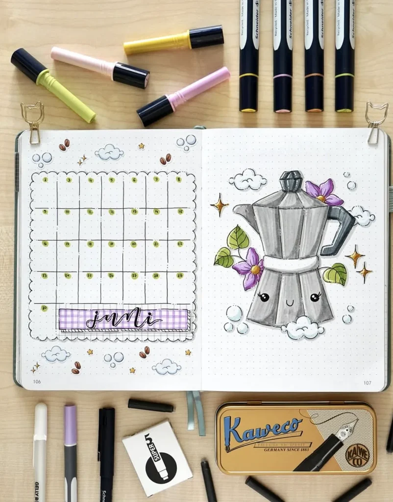 Bullet journal with June calendar and moka pot illustration, surrounded by colorful markers and pens.