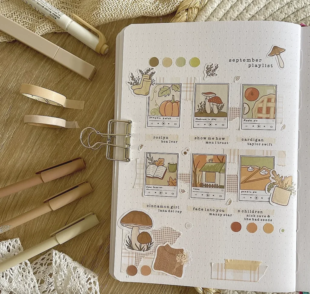 Autumn-themed scrapbook with playlists, doodles, and earth-tone art supplies on a wooden table.