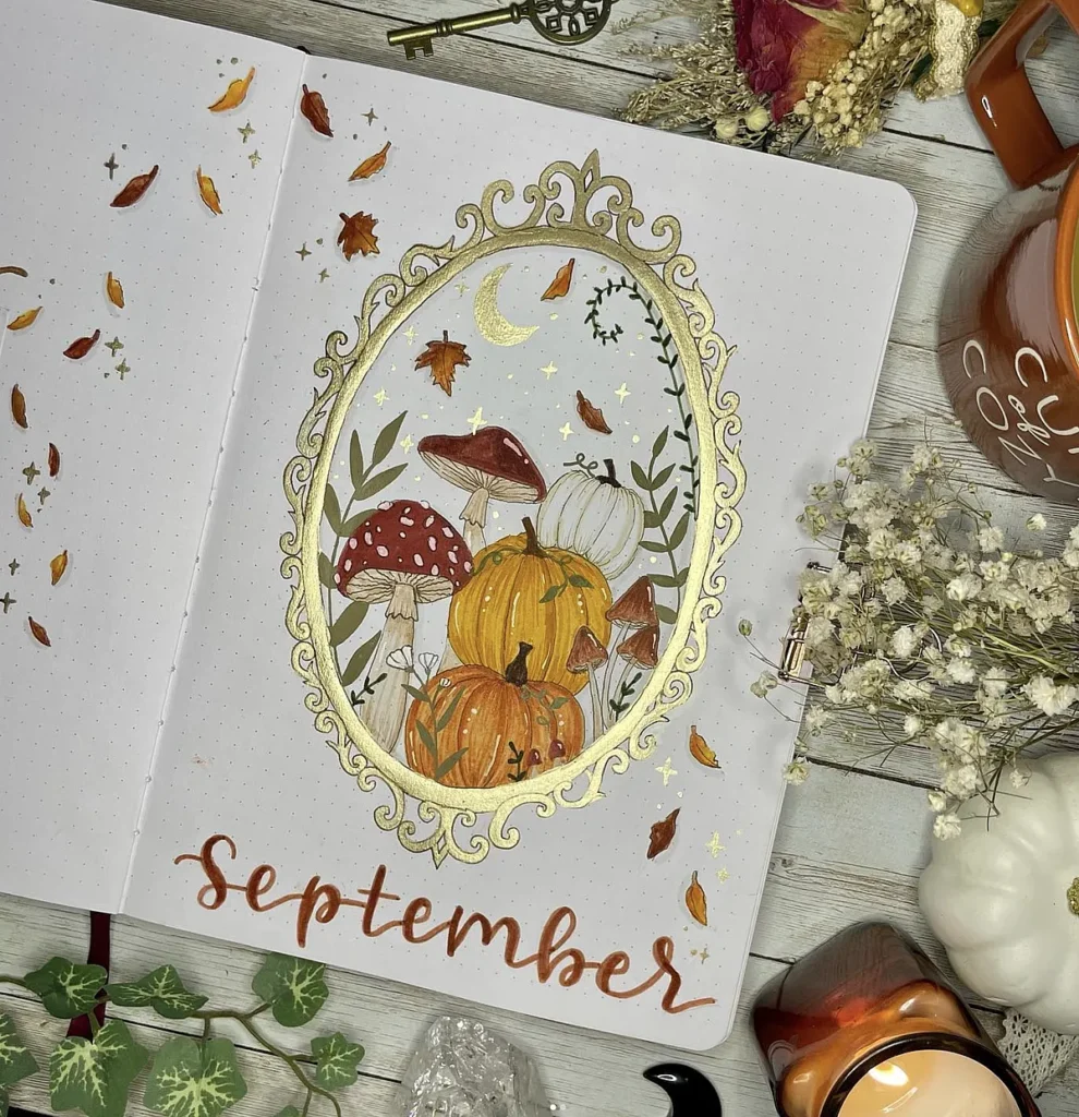 September bullet journal page with mushrooms, pumpkins, and fall leaves in a decorative frame, surrounded by cozy items.