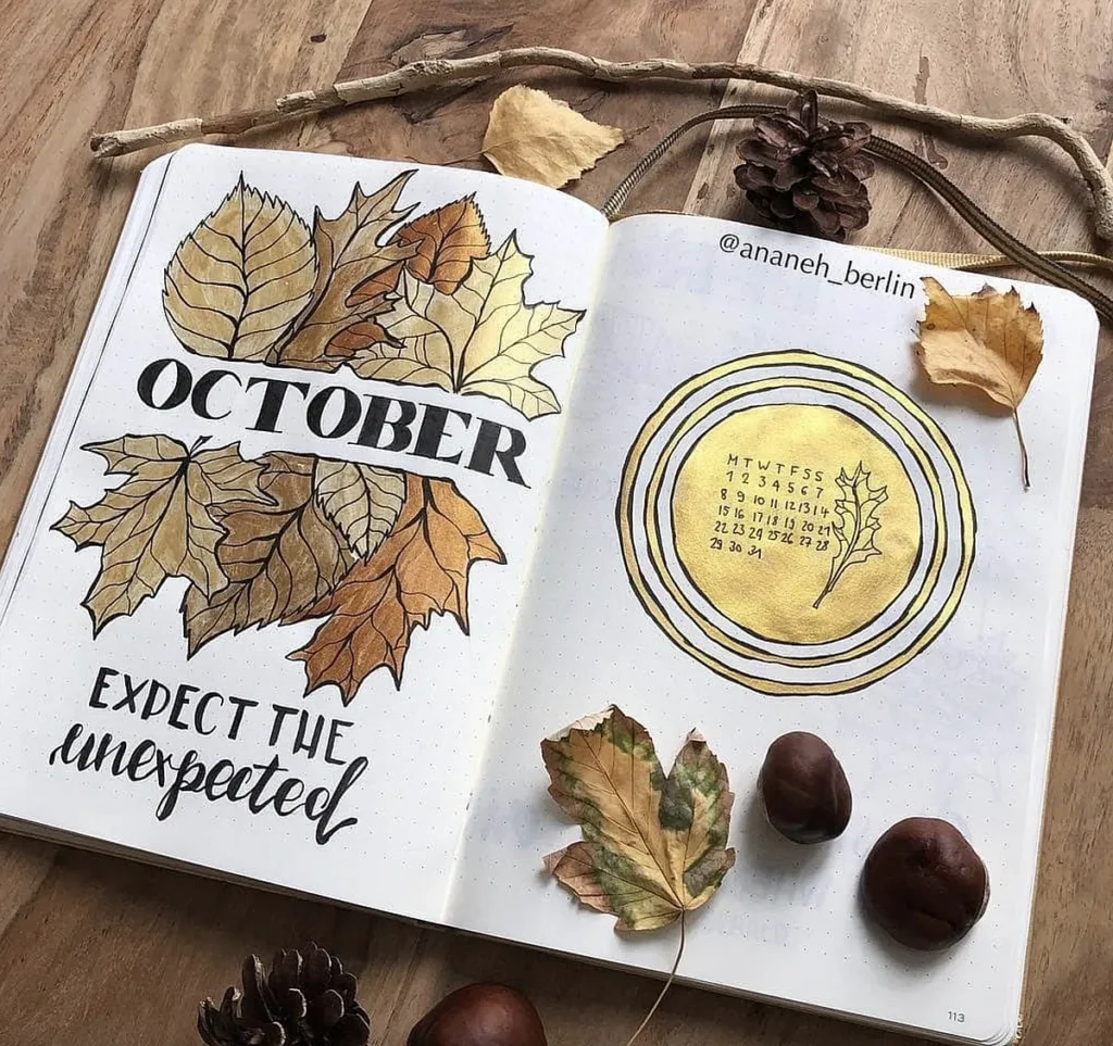 October bullet journal spread with autumn leaves, calendar, and chestnuts on wooden background.