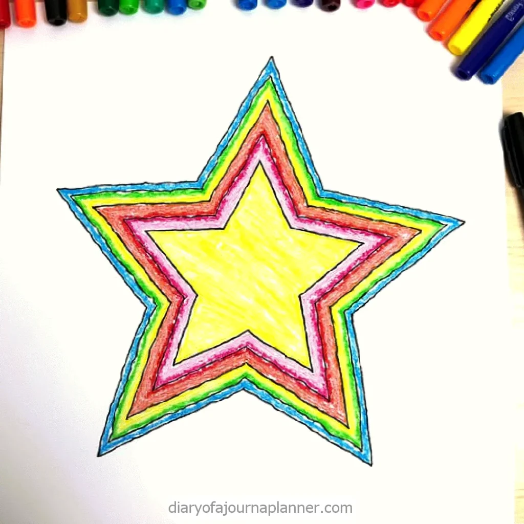 Colorful crayon star drawing with rainbow outlines on white paper, surrounded by various colored pens and pencils.