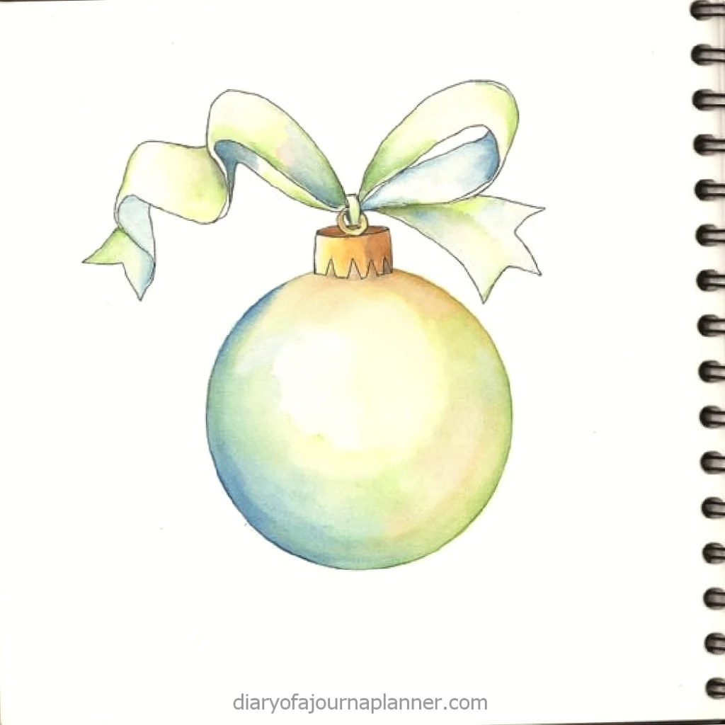 Watercolor Christmas ornament with green and blue shades, tied with a ribbon.