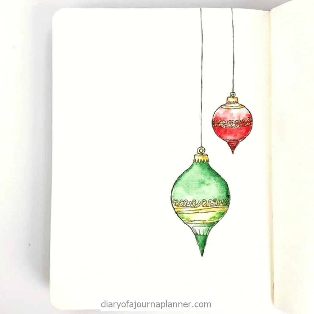 Watercolor Christmas ornaments doodle in a notebook, featuring red and green decorative baubles hanging elegantly.