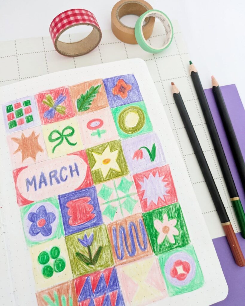 Colorful March calendar with doodles, colored pencils, and washi tape on a grid notebook, enhancing creativity.