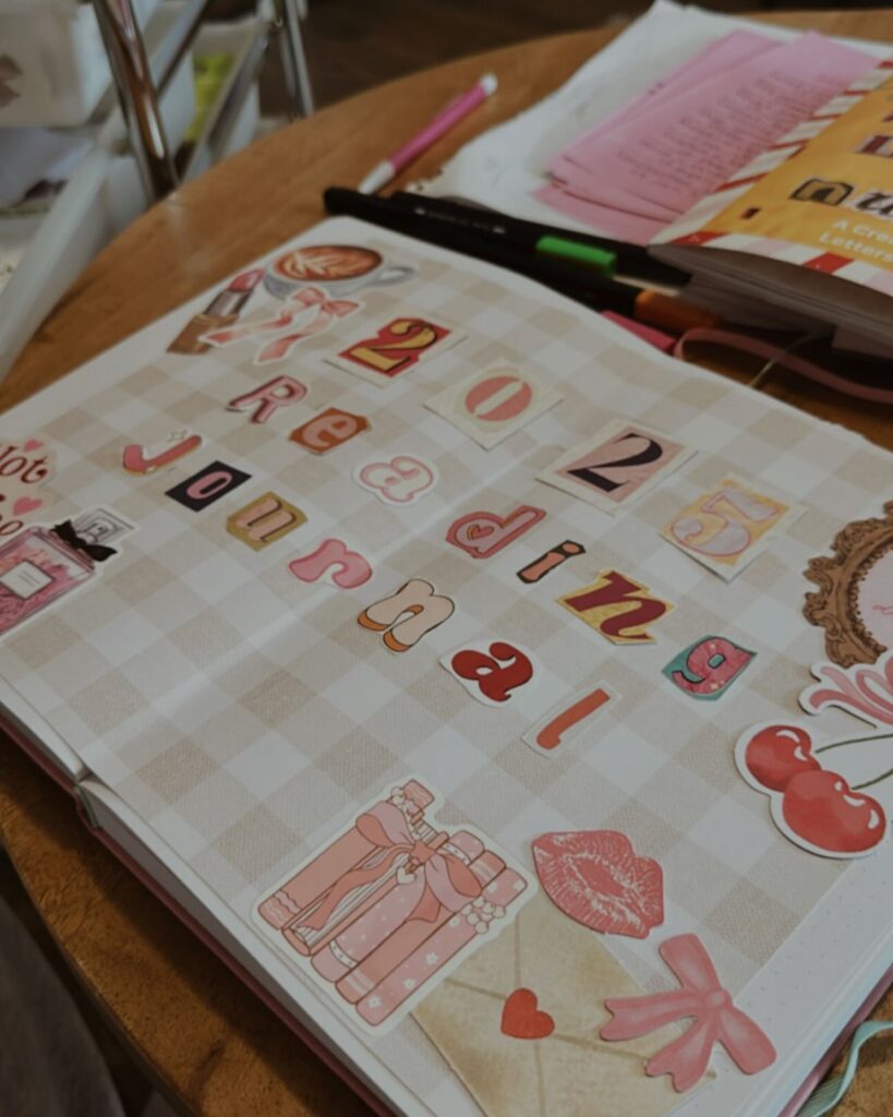 Creative 2023 reading journal on a table, embellished with colorful stickers and decorative letters.