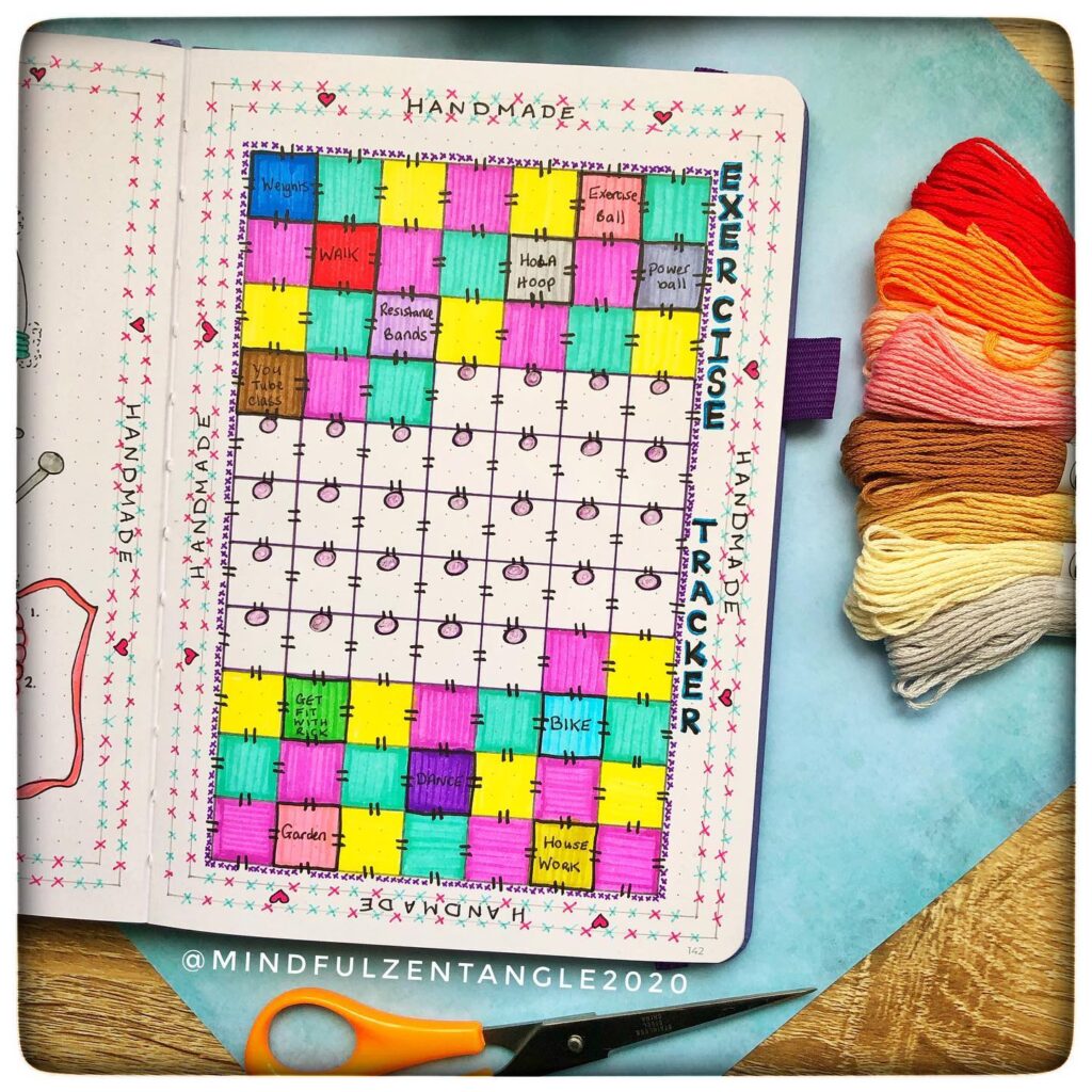 Colorful exercise tracker journal with yarn and scissors on the side, promoting organized fitness planning.