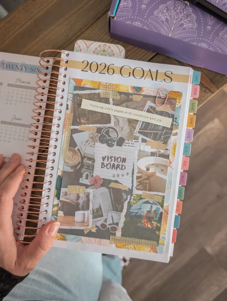 Open planner showing a colorful vision board for 2026 goals with tabs and decorative stickers.