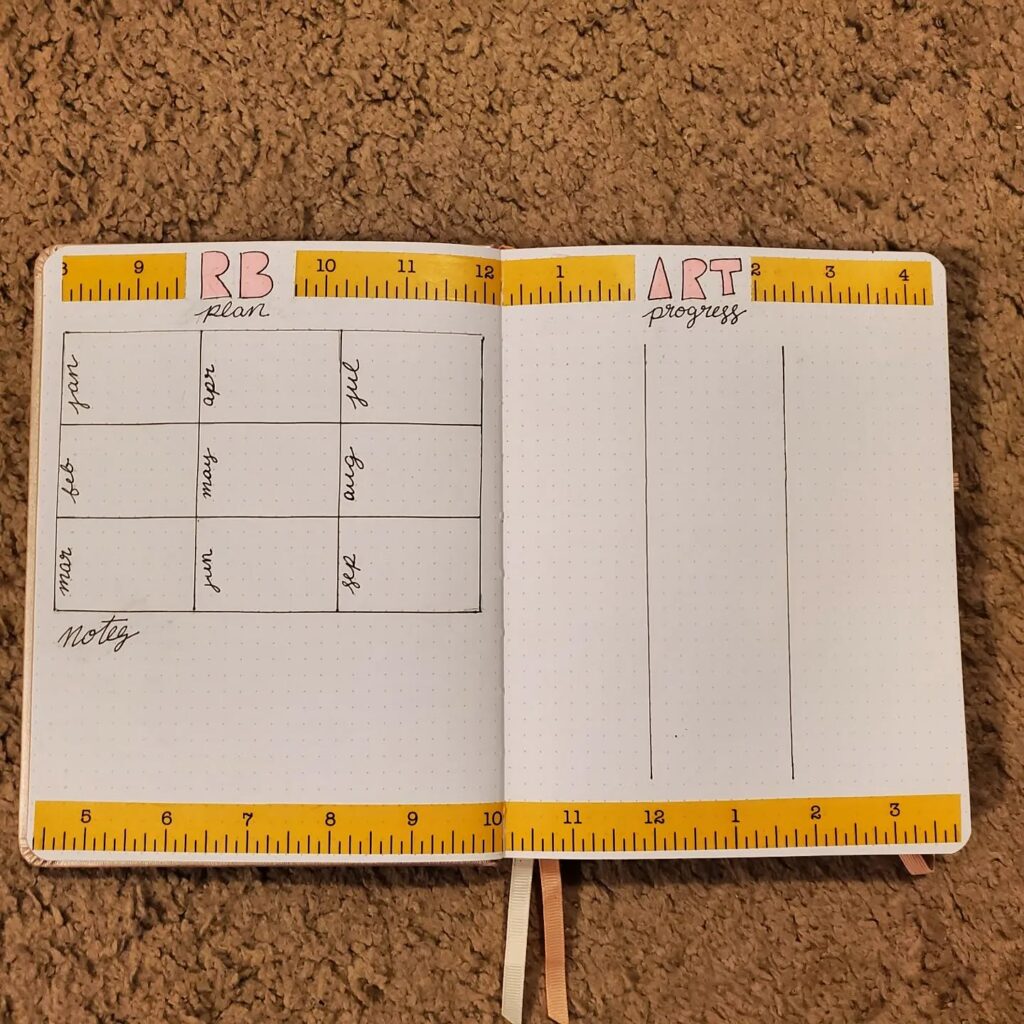 Open bullet journal with a monthly planner and art progress tracker on a dotted page layout.