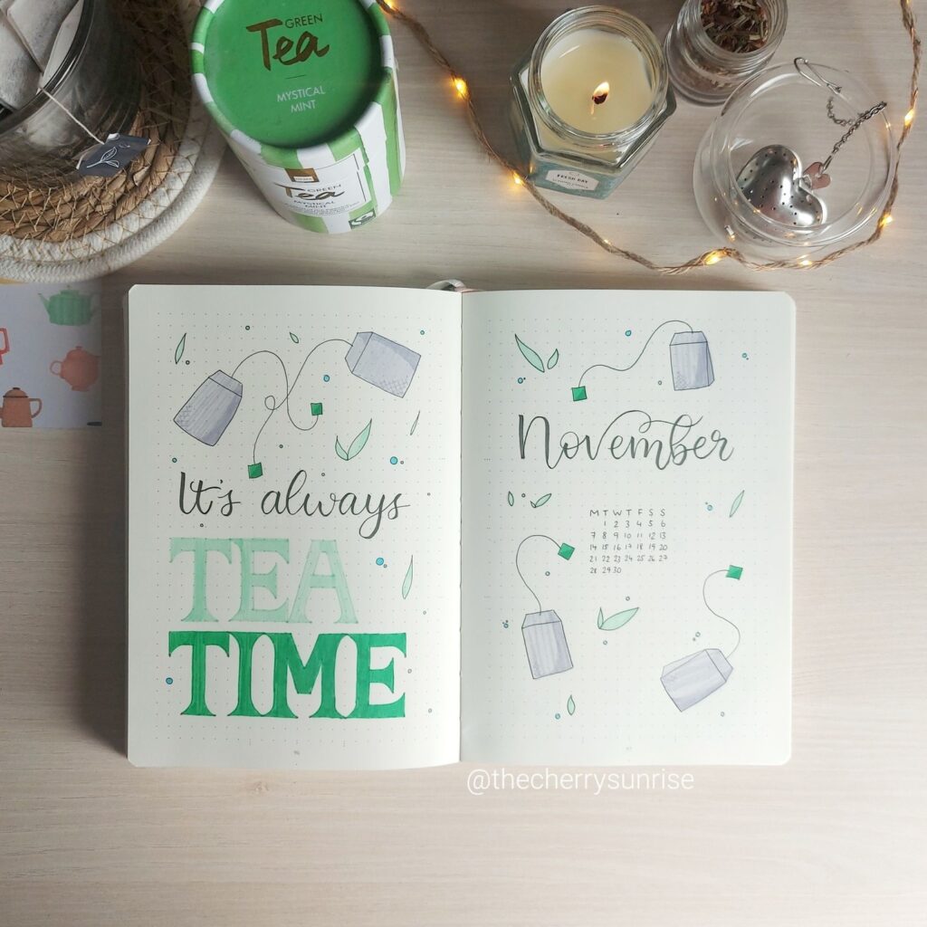 Bullet journal with It's always tea time and November calendar, surrounded by tea-themed items.