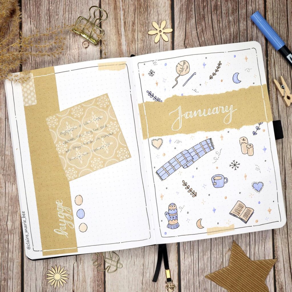 Bullet journal spread for January with cozy winter-themed doodles and hygge-inspired elements on a wooden background.