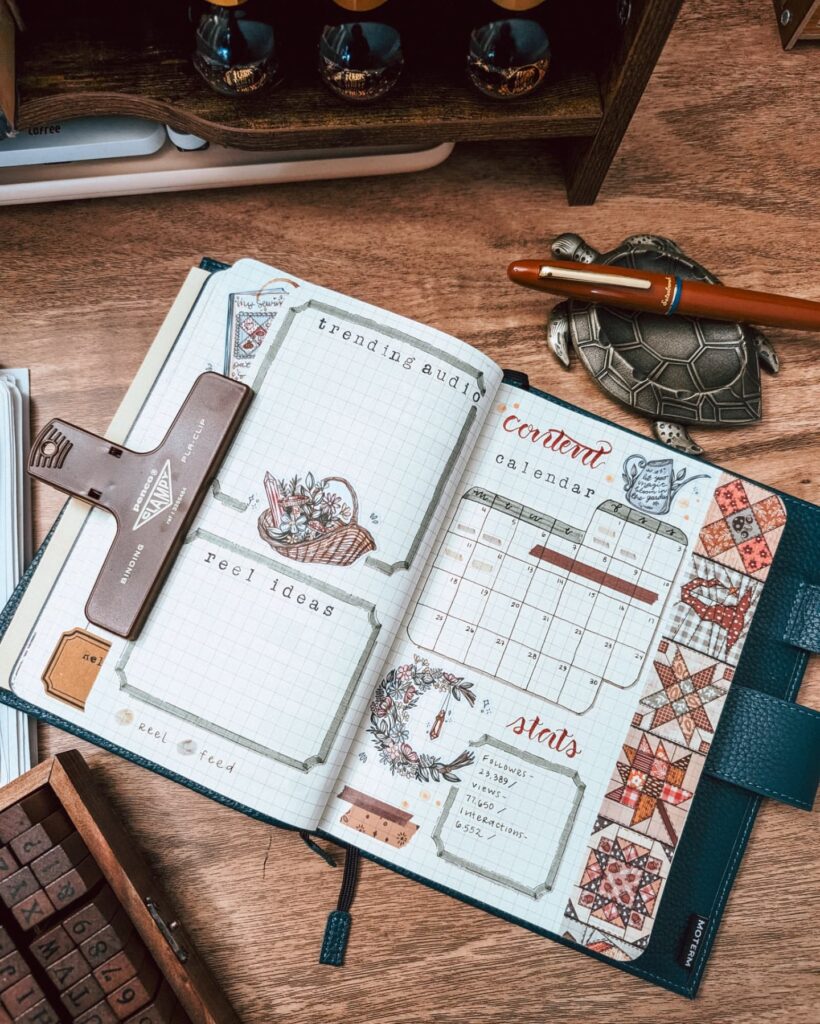 Open planner on wooden desk with sections for trending audio, reel ideas, and content calendar featuring decorative elements.