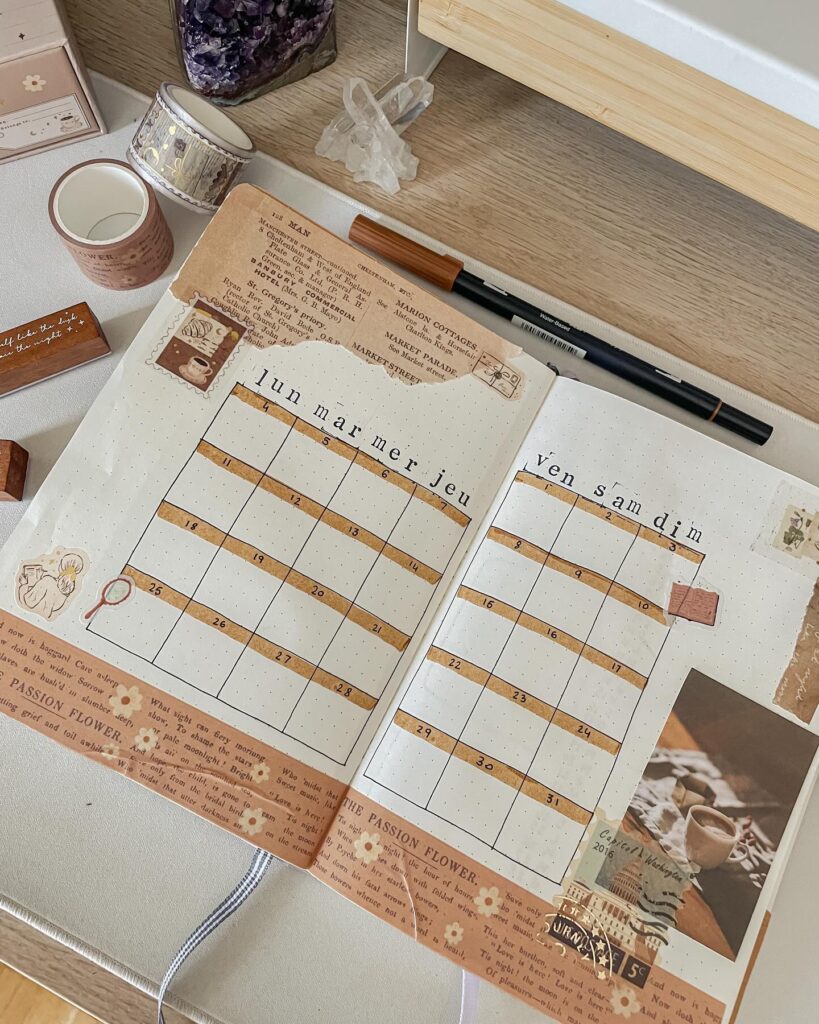 Decorative journal spread with calendar layout on a desk with washi tape and stationery.
