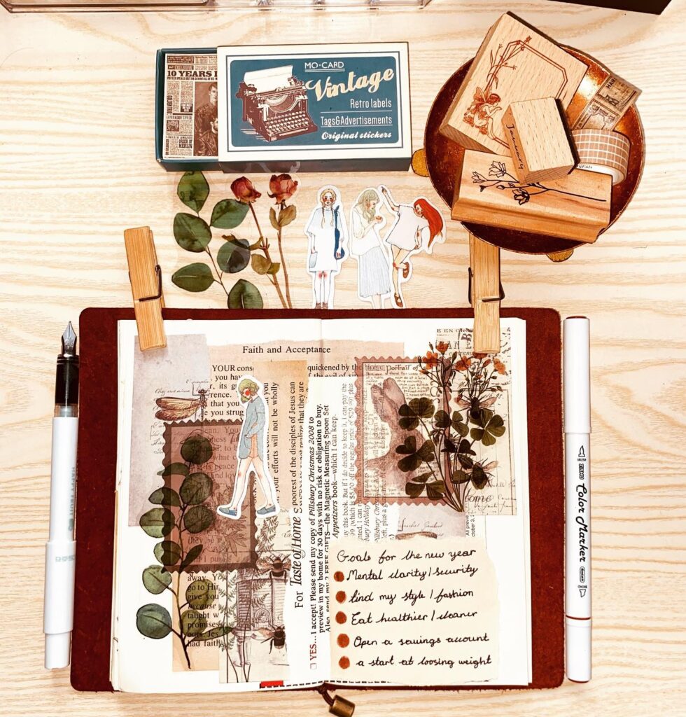 Vintage journal layout with retro labels, stickers, floral designs, and handwritten goals on a wooden desk.