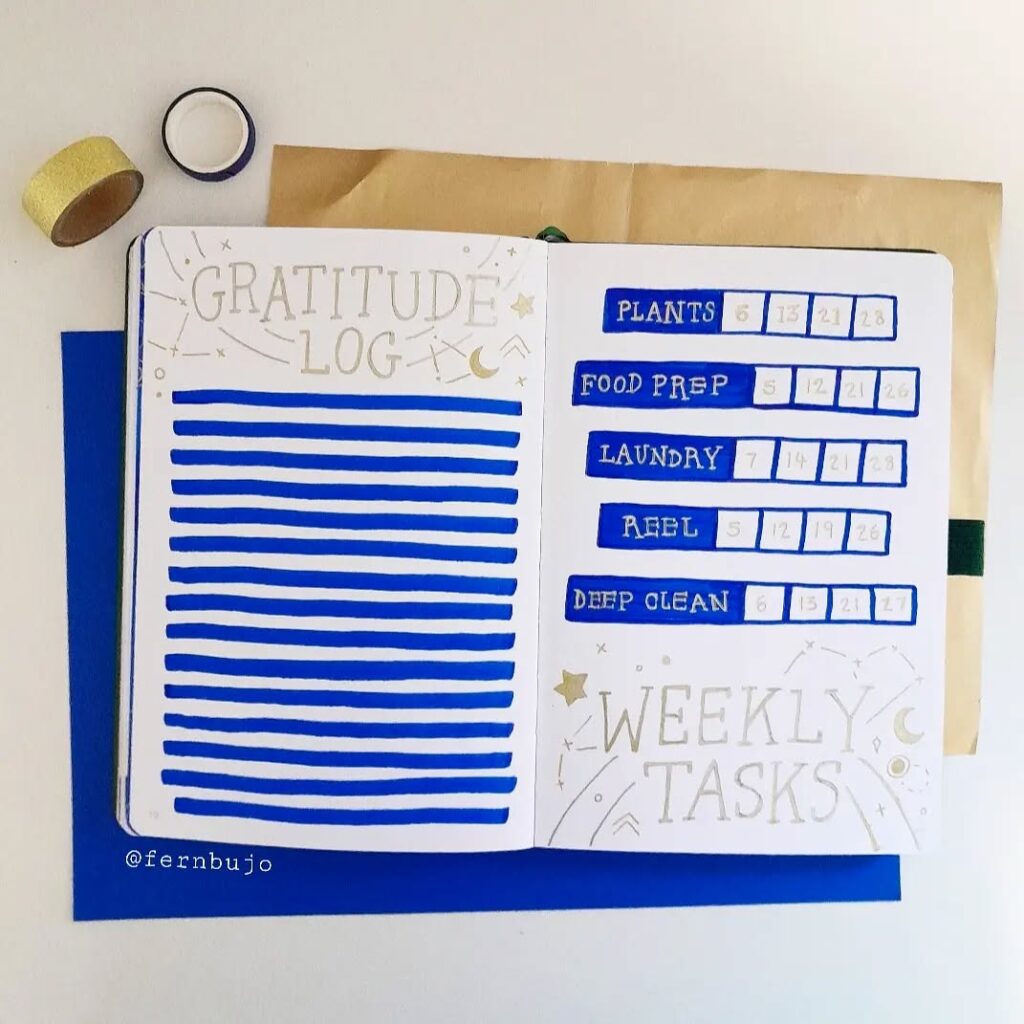 Open bullet journal with gratitude log and weekly tasks in blue, star and moon design, washi tape beside.