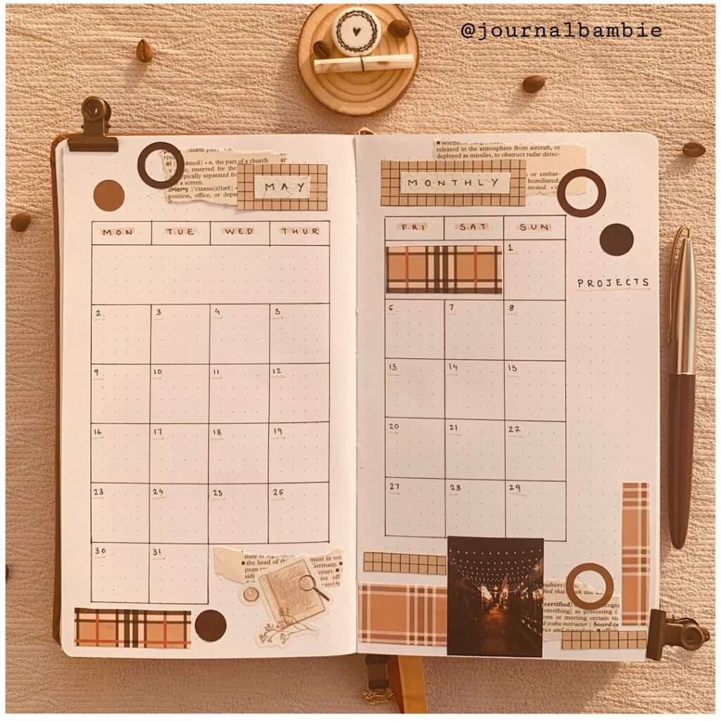 Decorative bullet journal May planner with creative monthly layout, featuring notes and embellishments.