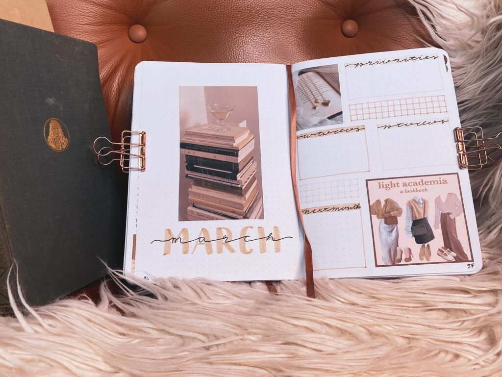 Open journal with March layout on cozy chair, featuring book stack photo and light academia lookbook.
