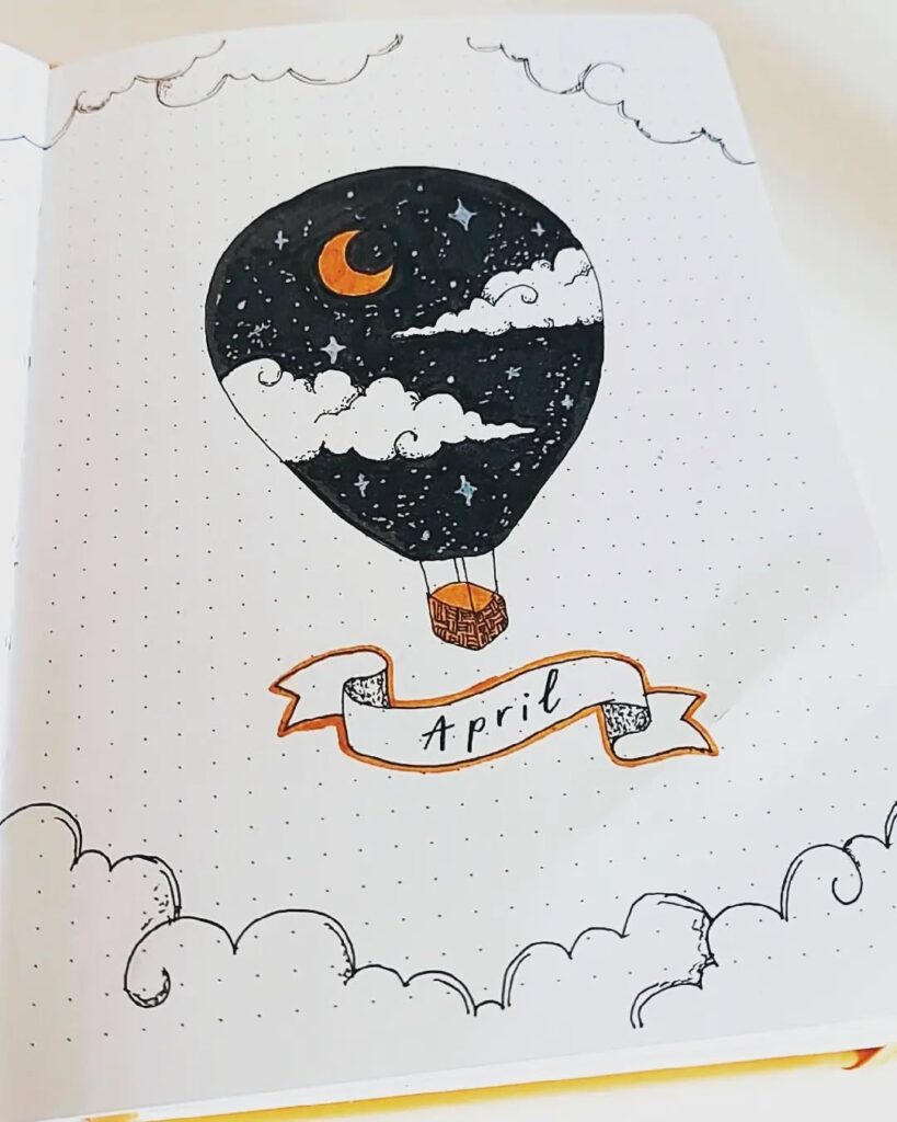 Illustrated hot air balloon with night sky design and April banner in a journal.