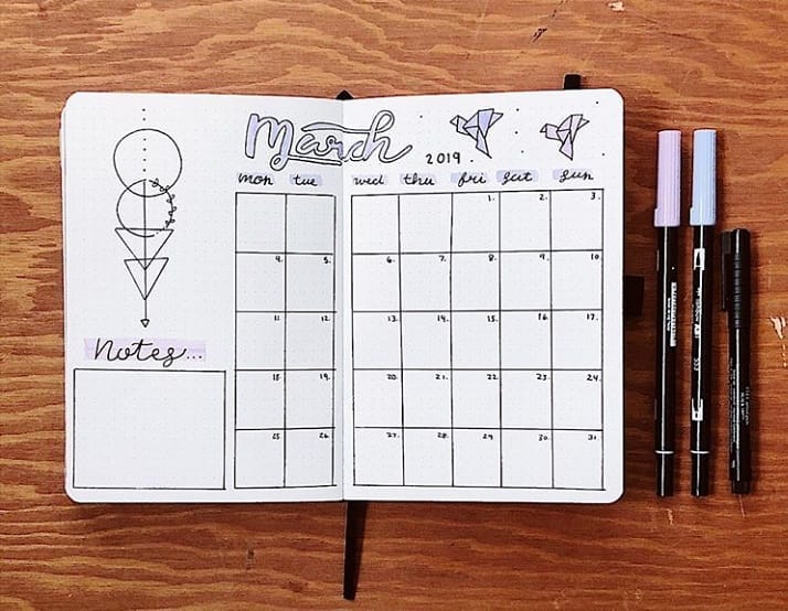 Bullet journal March 2019 monthly spread with notes section and pens on wooden background.
