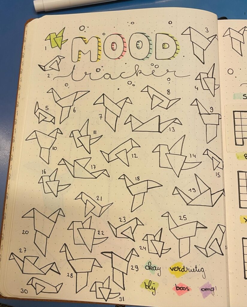 Origami-themed mood tracker in bullet journal, featuring numbered birds and color-coded emotions.