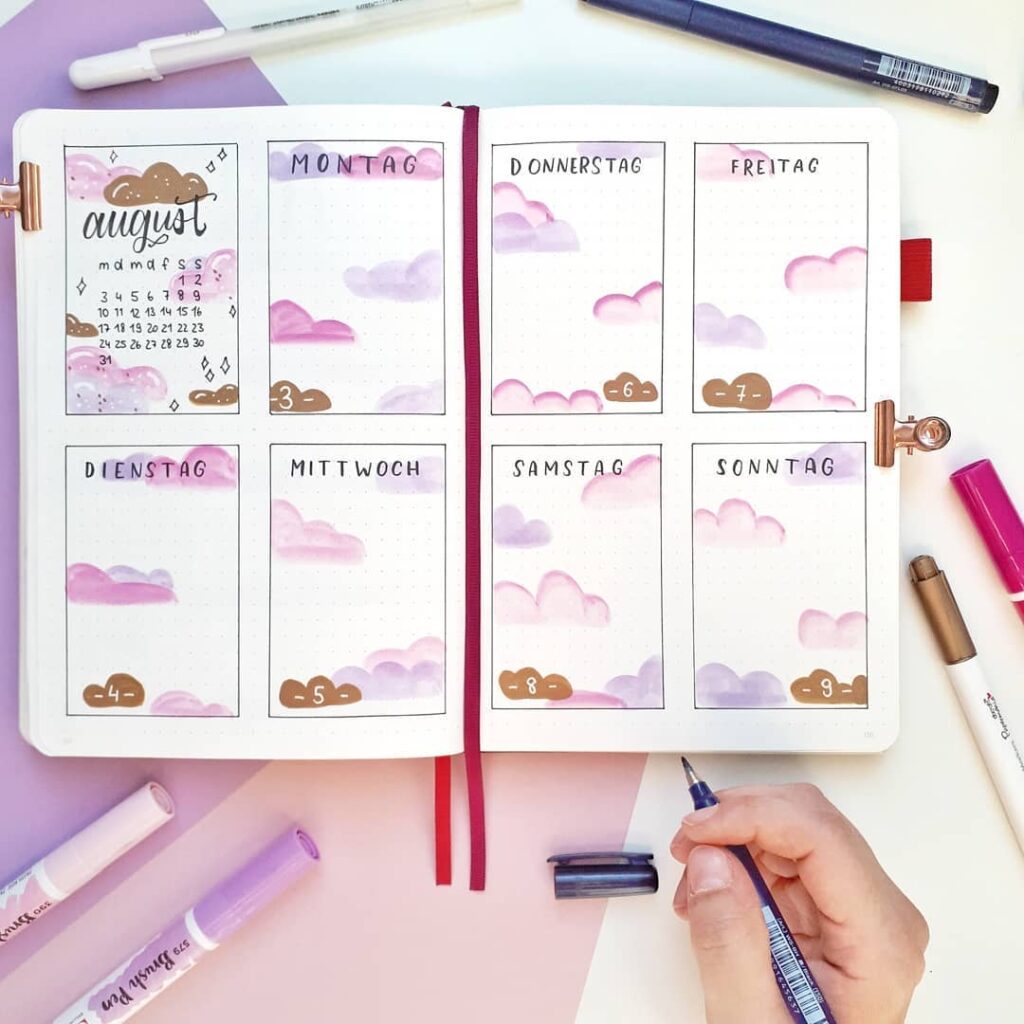 Handcrafted bullet journal weekly spread with pastel colors and cloud theme, focusing on August scheduling.