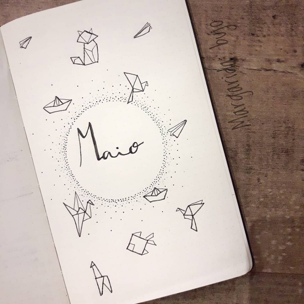 Bullet journal page for May with origami designs, including boats and animals, in black ink on white paper.